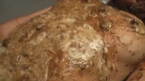 Asian brunette covered in mud during solo living room session